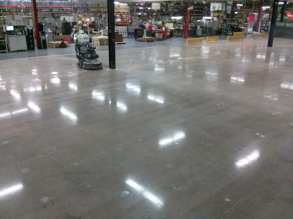 Showing the final polishing step of the concrete polishing process where the contractor grinds the floor with a high grit diamond tooling.