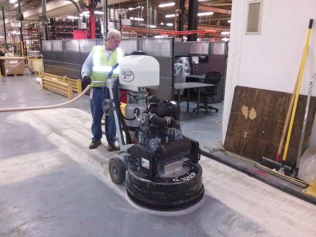 Worker starting the initial grind of concrete polishing in an industrial space in Wisconsin.