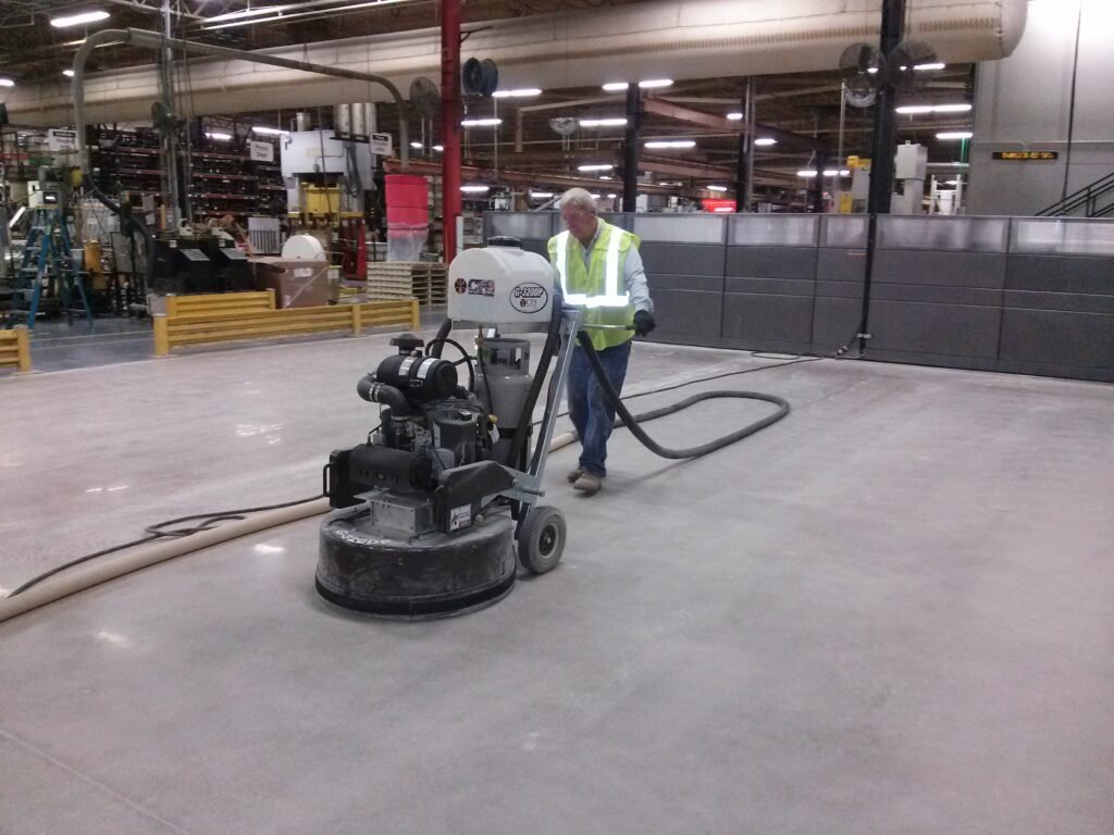 This is the intermediary step of the concrete polishing process where a contractor is grinding the floor with a medium grit diamond tooling.