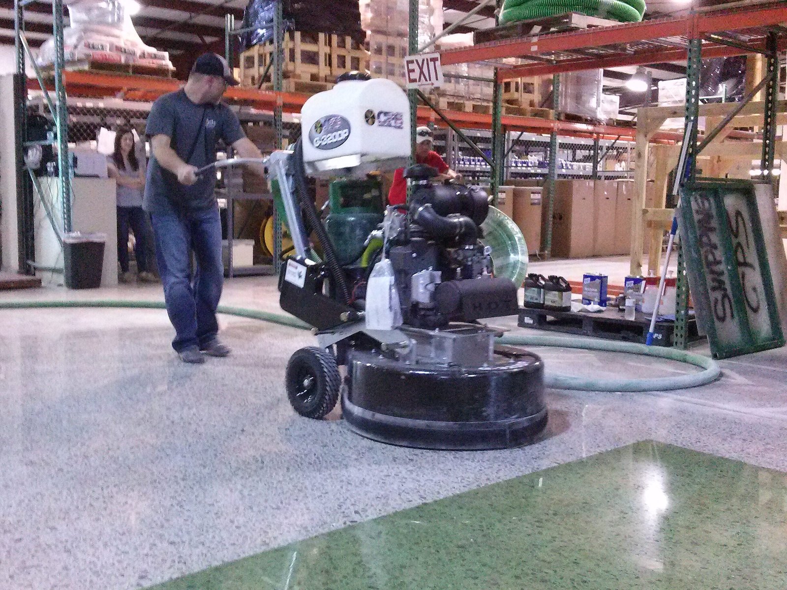 This is a photo of a CPS floor polishing machine polishing a concrete floor in a warehouse with some green dyed polished concrete.