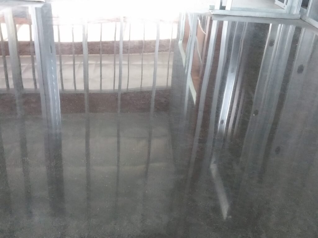 Polished concrete floor that has a high reflectivity that is reflecting the ceiling in the floor.