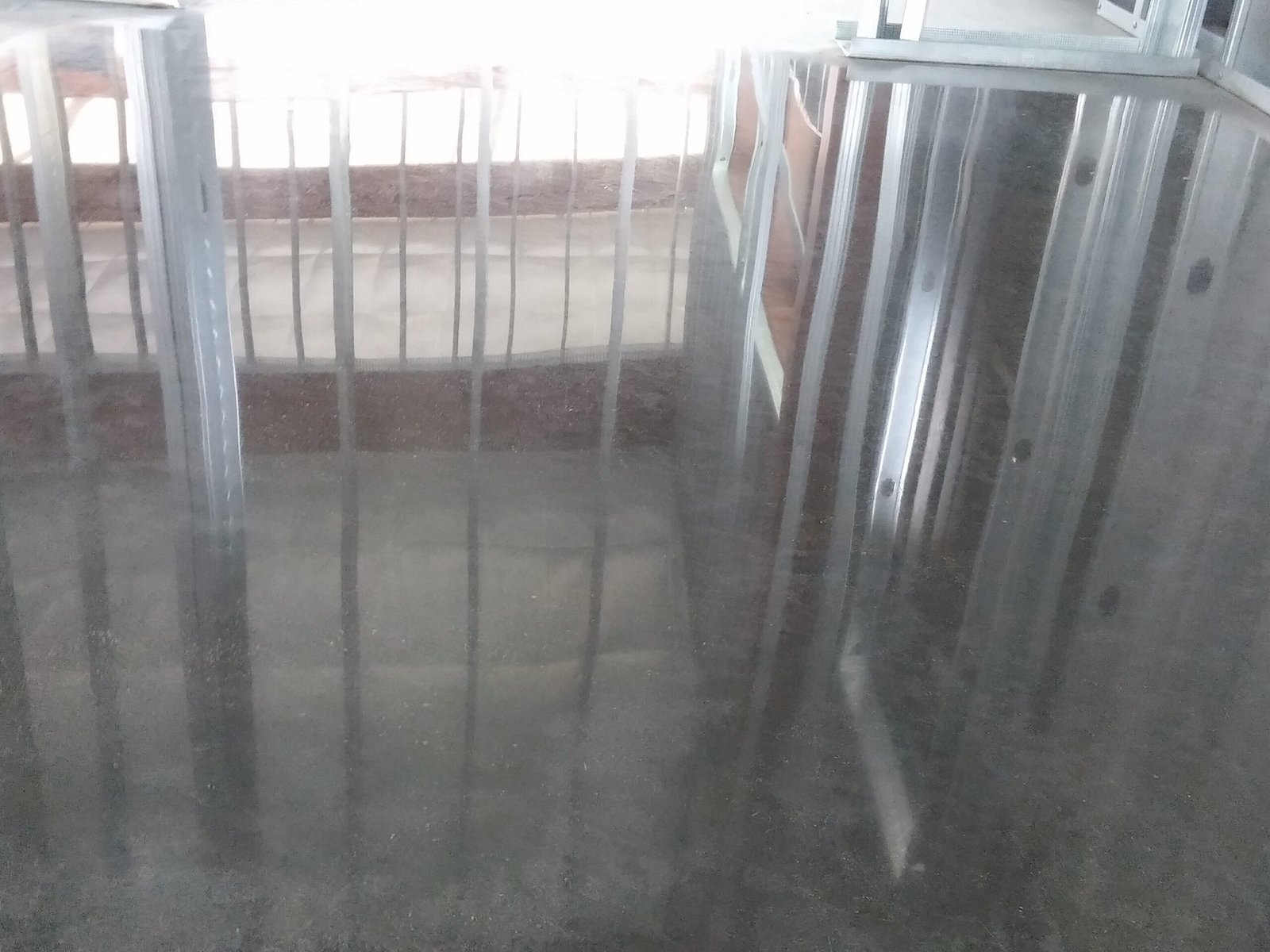 Polished concrete floor that has a high reflectivity that is reflecting the ceiling in the floor.