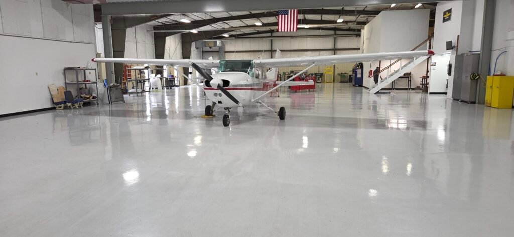 A gray polyaspartic concrete coating in an airplane hanger in Baraboo, Wisconsin. Installed by Wisconsin Industrial Services and Equipment.
