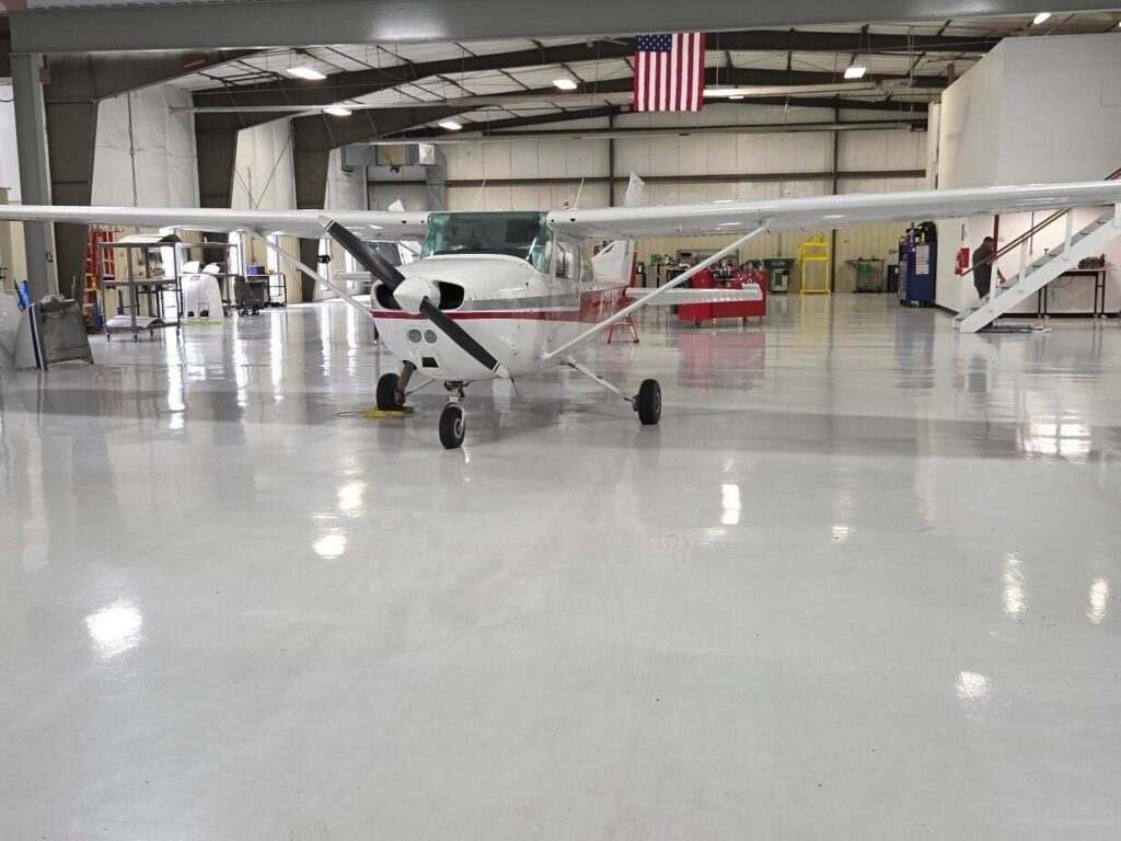 A gray polyaspartic concrete coating in an airplane hanger in Baraboo, Wisconsin. Installed by Wisconsin Industrial Services and Equipment.