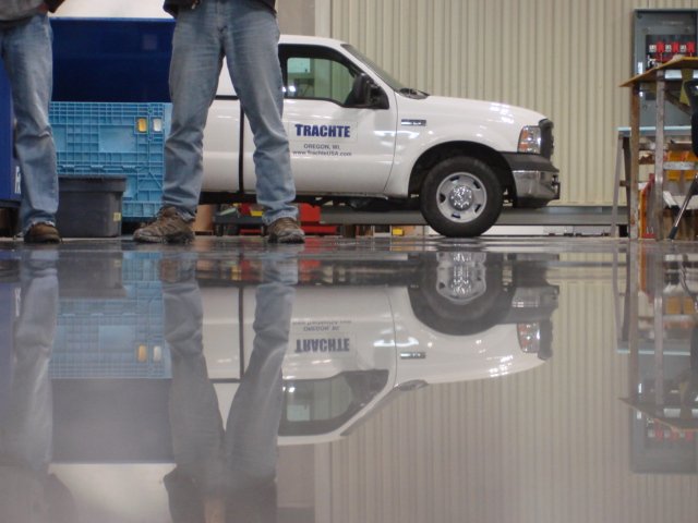 A highly reflective polished concrete floor showing a mirror image of the surrounding in the floor.