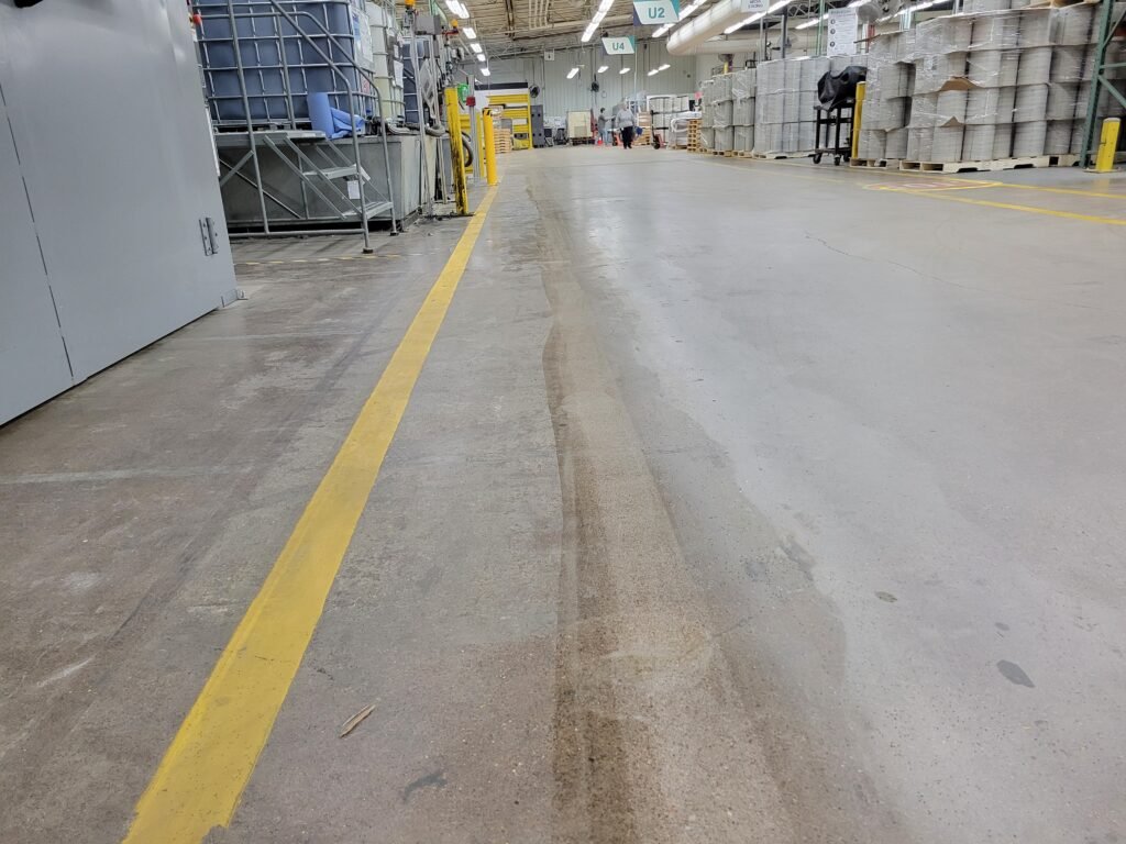 Shows an area in a manufacturing plant where an industrial stripe was removed.