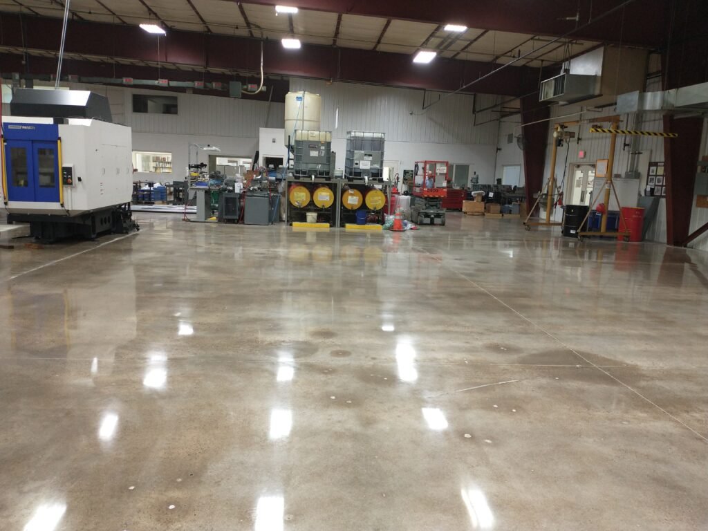 A mid level polished concrete floor in an industrial manufacturing plant in Wisconsin. Showing reflectivity of overhead lights and a smooth and durable surface.