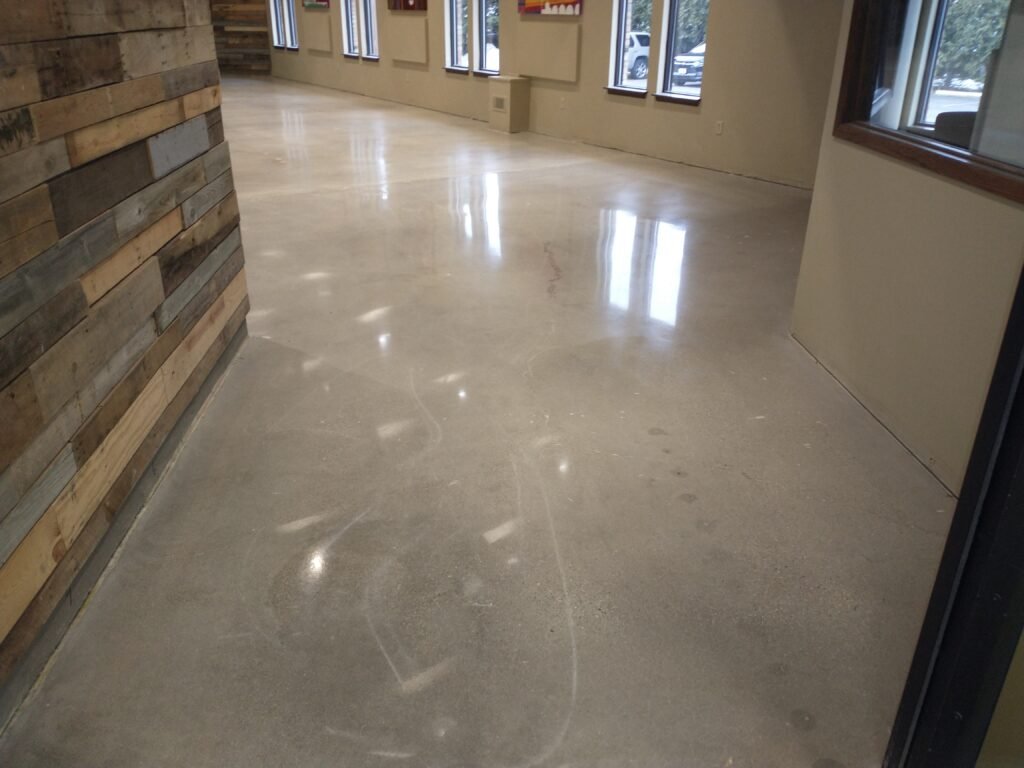 A mid luster polished concrete floor in a hallway of a commercial building in Madison, Wisconsin. Shows smooth, durable, and reflective surface that is easy to maintain and clean.