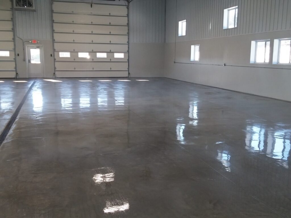 A concrete polyaspartic clear coat installed in an automotive shop that shows the reflective floor.