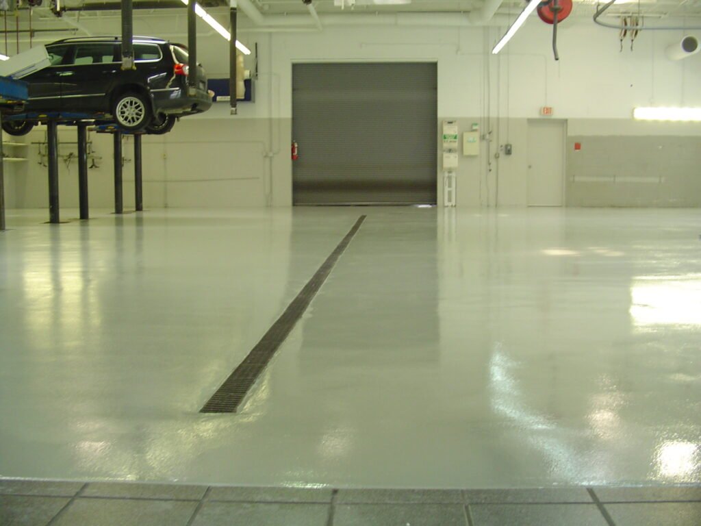 A white polyaspartic concrete coating installed in an automotive shop in Wisconsin for its durability and ease of cleaning and maintenance.