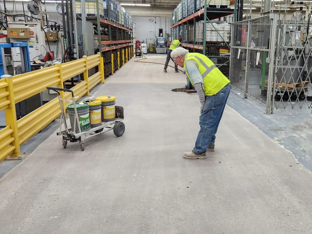 A worker inspecting the concrete densifier during the concrete polishing process.