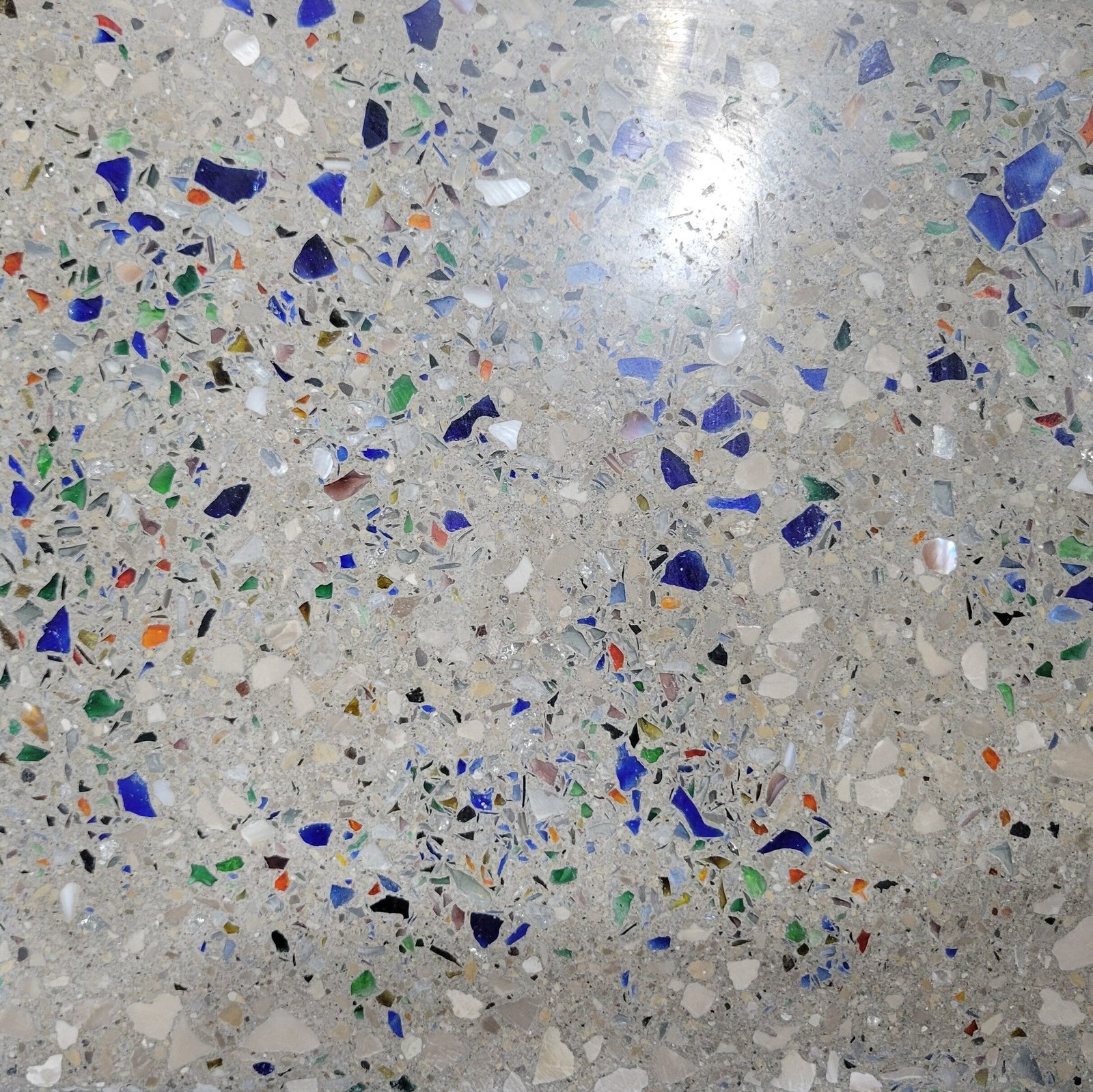 Close up of a polished concrete floor with colored glass additives.
