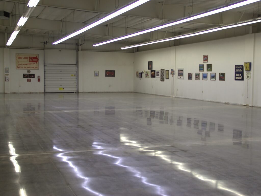 Mid level polished concrete floor showing the smooth and durable reflectivity of the walls and lighting. Made for a car showroom in Wisconsin.