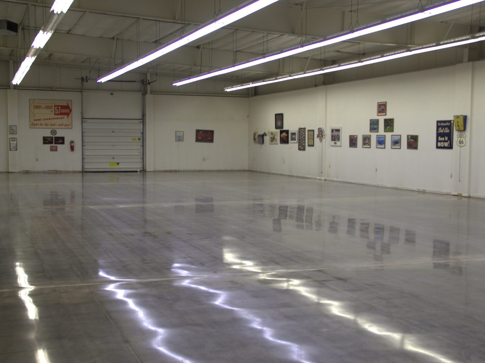 Mid level polished concrete floor showing the smooth and durable reflectivity of the walls and lighting. Made for a car showroom in Wisconsin.