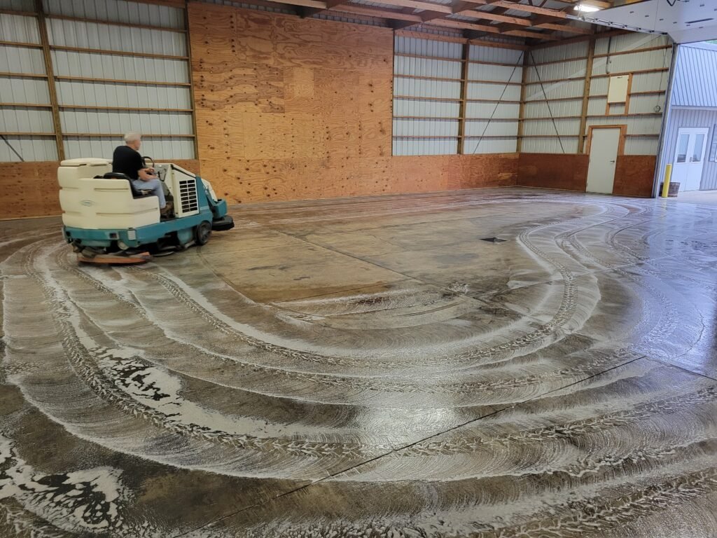 Cleaning a warehouse in Montello, Wisconsin with a rideable sweeper scrubber machine.