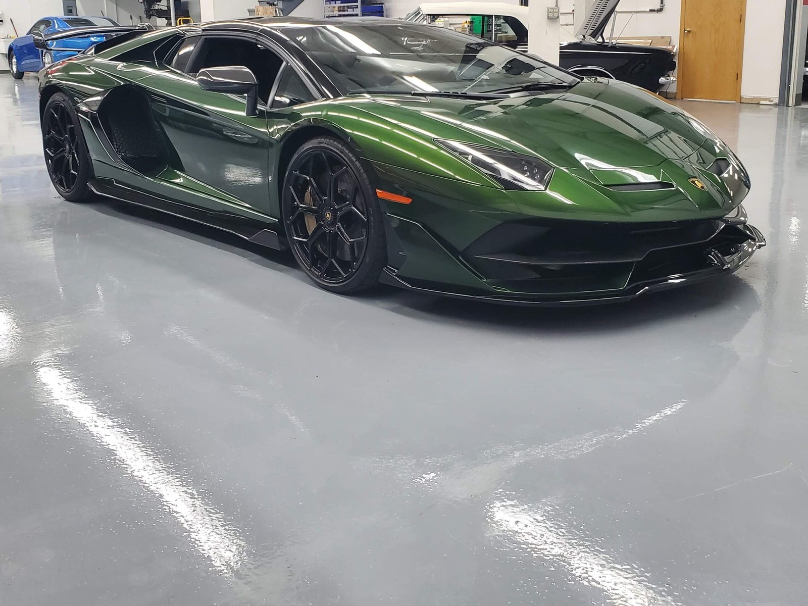 A green Lamborghini sitting on a gray polyaspartic concrete coating that works great for automotive shops due to style, ease of cleaning, and durability.